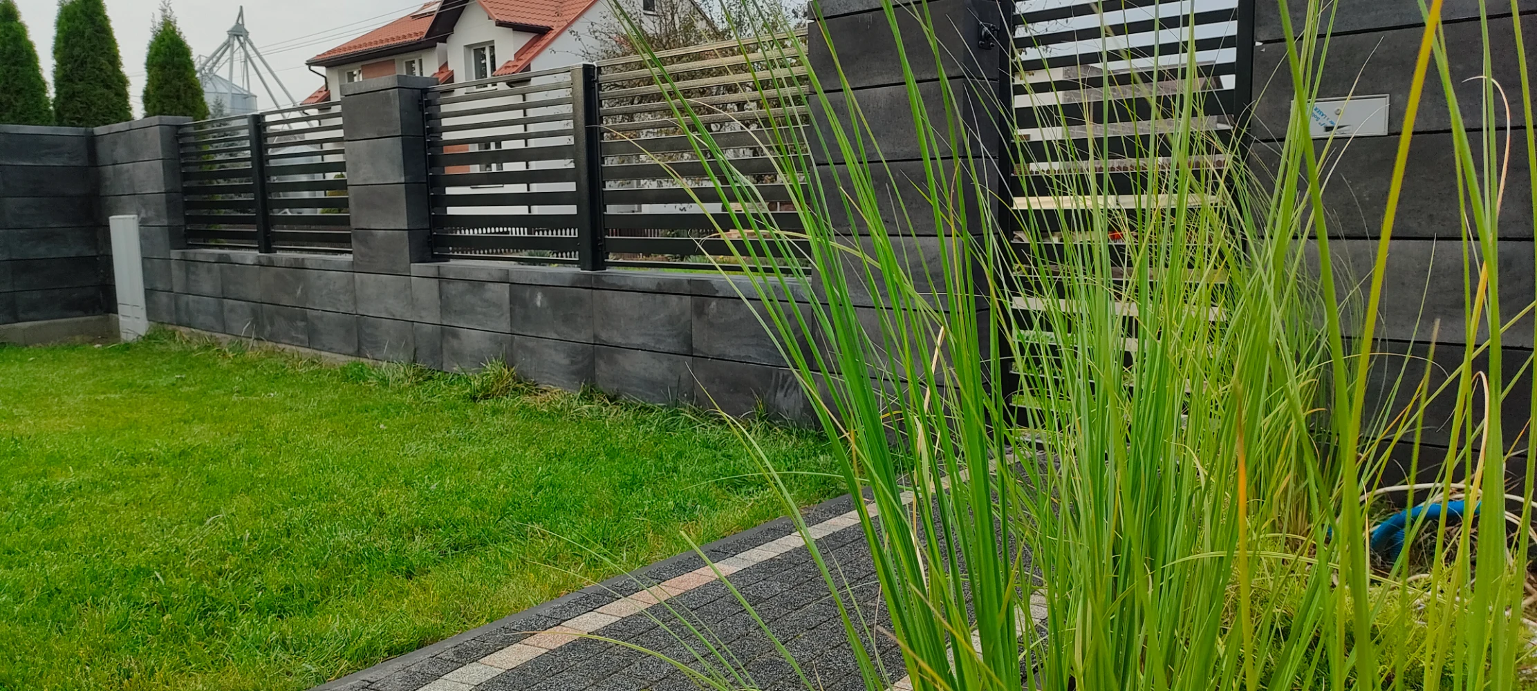 czarne, nowoczesne palisadowe ogrodzenie połączone z bloczkiem